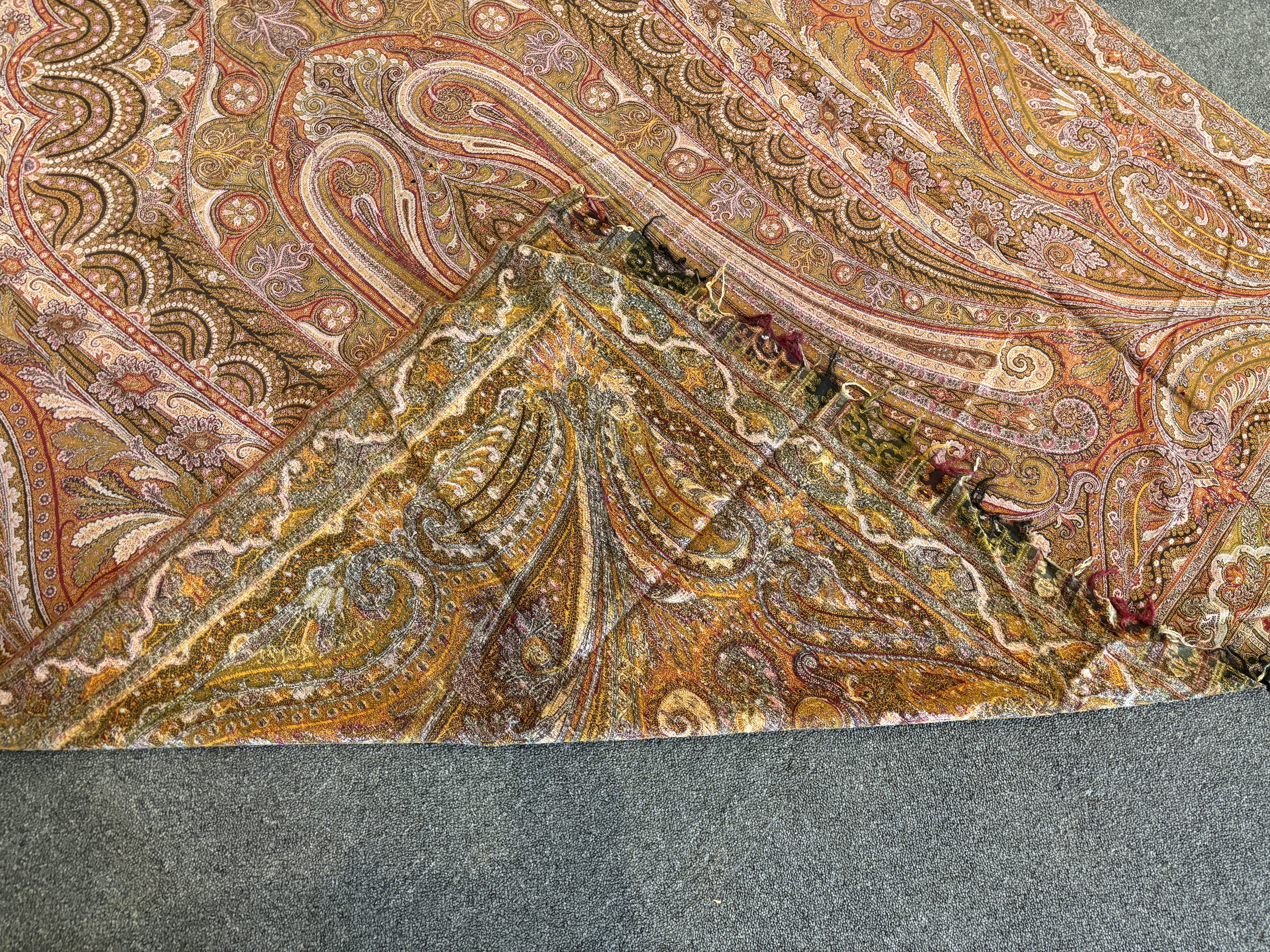 A 19th century woven Scottish Paisley wool shawl, bordered on four sides and fringed on two, woven with two ornate teardrop designs and a central cartouche, 334cm long x 160cm wide